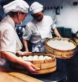 Chefs preparing dumplings in kitchen