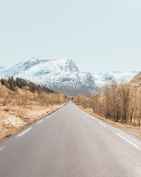 Road by mountains against clear sky