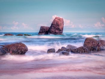 Rocks in sea against sky