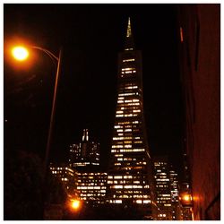 Low angle view of illuminated buildings against sky at night