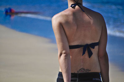 Midsection of woman standing at beach