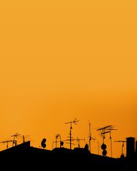 Low angle view of silhouette roof against sky during sunset