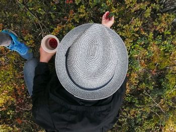 Rear view of man holding hat on field