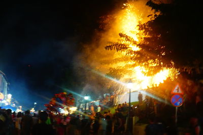 Crowd at music concert against sky at night