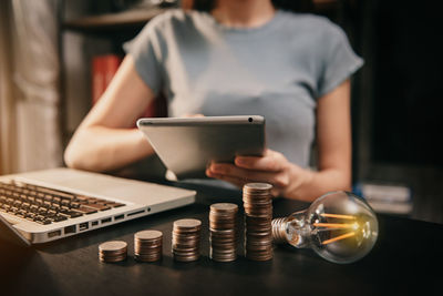 Midsection of woman holding smart phone on table