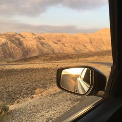 Reflection of mountains in side-view mirror