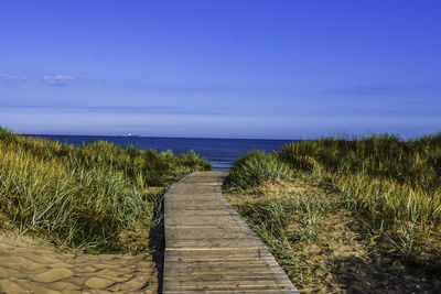 Wooden footbridge through the sand dunes to the sea