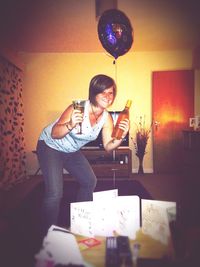 Full length of a young woman drinking glass