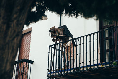 Low angle view of person photographing on balcony