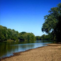 Scenic view of lake against clear blue sky