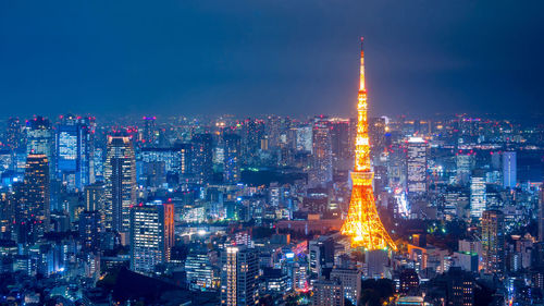 Illuminated cityscape against sky at night