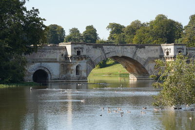 Arch bridge over river against sky