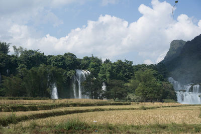 Scenic view of waterfall against sky