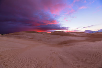Scenic view of desert against sky during sunset