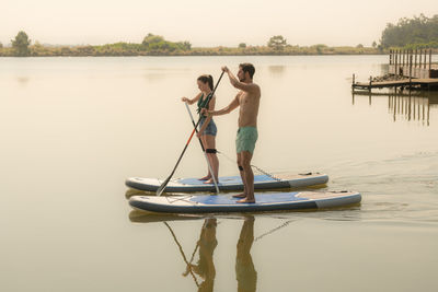 Rear view of woman kayaking in lake