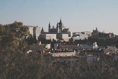 Buildings in city against clear sky