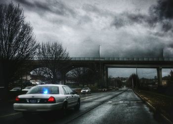 Car on road against cloudy sky