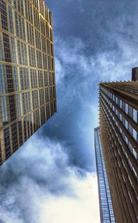 Low angle view of modern building against cloudy sky