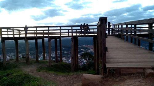 Footbridge over sea against sky