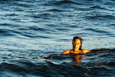 Young woman swimming in the sea near a beach in caraiva in bahia