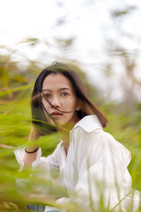 Portrait of young woman sitting on field