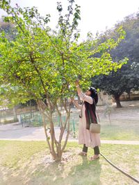 Full length of woman standing by plants