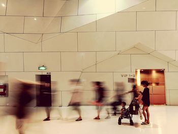 Blurred motion of people walking in illuminated city