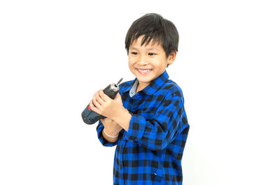 Portrait of smiling boy standing against white background
