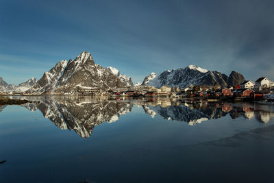 Scenic view of lake by snowcapped mountains against sky