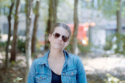Portrait of young woman in sunglasses at forest