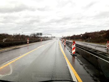 Man on road against cloudy sky