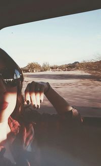Close-up of woman hand against sky