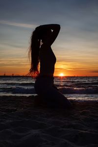 Silhouette woman on beach during sunset