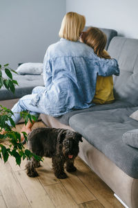 Side view of young woman sitting on sofa at home