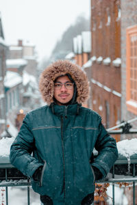 Portrait of man wearing warm clothing standing in city during winter