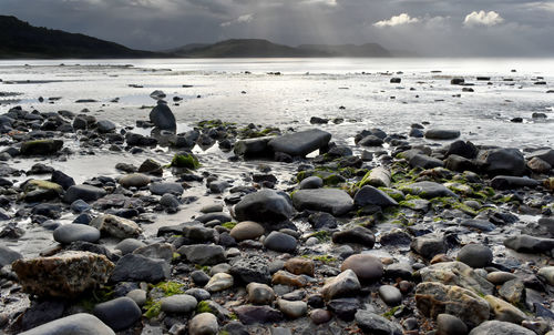 Pebbles on beach against sky