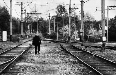 Full length of man standing on railway tracks against train