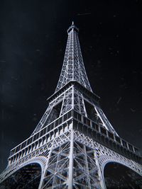 Low angle view of illuminated tower against sky at night