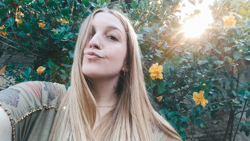 Portrait of young woman against plants