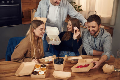 Portrait of friends having food at home