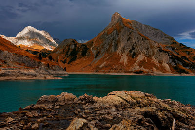 Scenic view of lake by mountains against sky