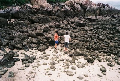 Rear view of people walking on rock