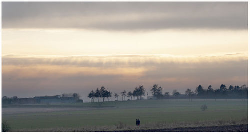 Scenic view of field against sky during sunset