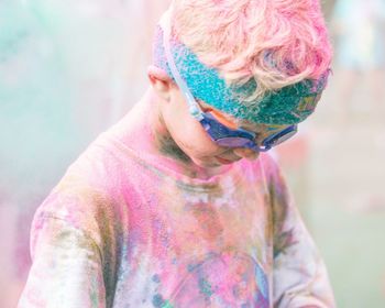 Midsection of child standing against multi colored background