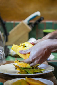 Close-up of hand holding leaf on table