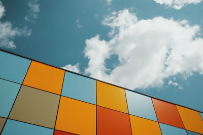 Colored tiles on wall against blue sky
