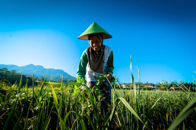 Man with umbrella on land against blue sky