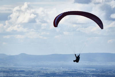 Person paragliding against sky