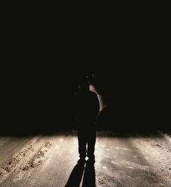 Silhouette of woman standing in dark room