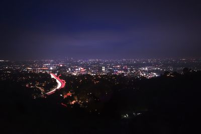 High angle view of illuminated city against sky at night